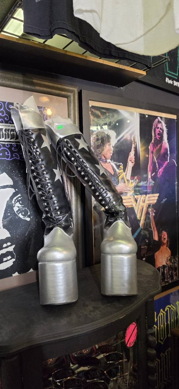 Silver and black platform boots alongside framed music posters